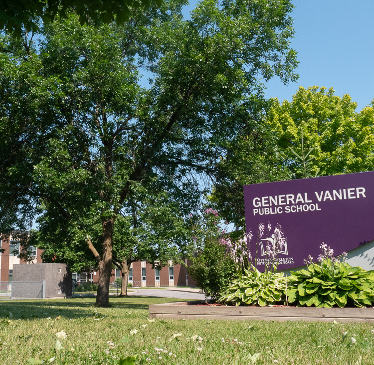 The general vanier school sign in the front of the school door.